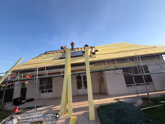 Maison sous échafaudage, toiture en cours de réfection