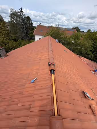 Faîtage en cours de pose sur une toiture en tuiles